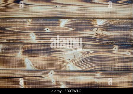 Vue de dessus rapprochée de planches en bois carbonisé avec un beau grain et des nœuds très contrastés. Surface en bois brun rustique idéale pour le design organique Banque D'Images