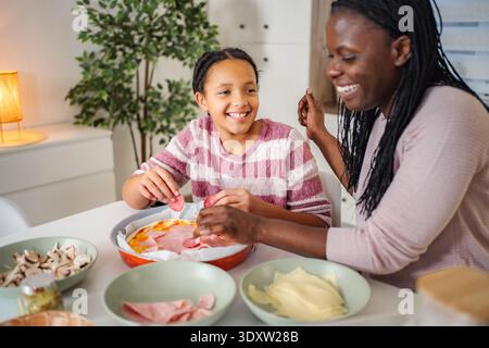 Mère et fille se liaient pour faire des pizzas maison ensemble Banque D'Images