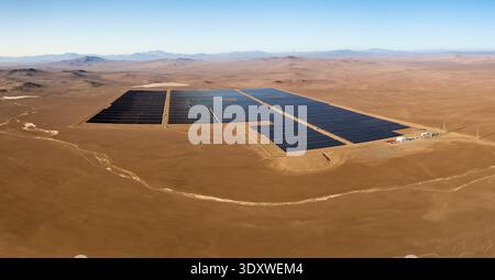 Ferme solaire à grande échelle dans le paysage aride du désert d'Atacama, présentant des infrastructures d'énergie renouvelable sous ciel clair. Vue aérienne incroyable Banque D'Images