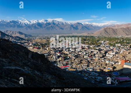 Vue surélevée sur la ville de montagne de Leh vers le sommet enneigé de Stock Kangri s'élevant au-dessus de la chaîne Stok au loin. Banque D'Images