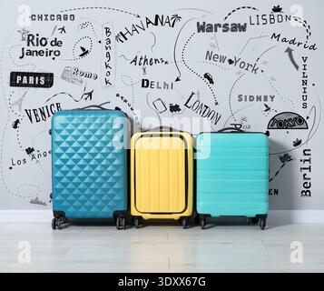 Planification du voyage. Valises contre le dessin des villes à visiter et symboles pour les méthodes de voyage sur mur gris Banque D'Images