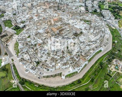 Superbe perspective aérienne d'Ostuni, Italie. Une vue parfaite de la ville blanche des Pouilles nichée parmi les oliveraies au-dessus de la mer Adriatique étincelante Banque D'Images