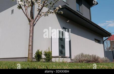 Unité extérieure d'une pompe à chaleur contre le mur d'un chalet moderne Banque D'Images