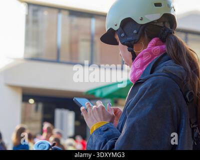 Jeune femme en équipement de cyclisme en utilisant smartphone à l'extérieur Banque D'Images