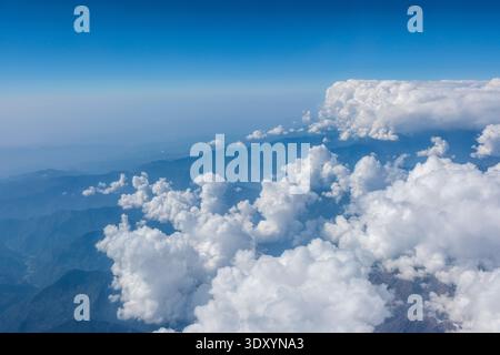 Vue aérienne des contreforts de l'Himalaya montrant une couche de nuages de cumulus blancs denses obscurcissant partiellement les crêtes sombres des montagnes ci-dessous. Chandigarh Banque D'Images