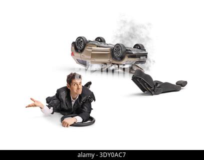 Homme confus dans un costume déchiré se trouve sur le sol avec un volant après un accident de voiture isolé sur fond blanc Banque D'Images
