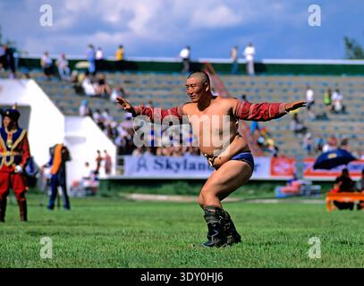 La lutte occupe le devant de la scène au festival Naadam à Oulan-Bator, en Mongolie, alors que les concurrents font preuve de compétence et de force sur le terrain vert. Banque D'Images