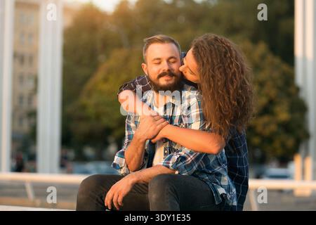 Couple profite du temps ensemble dans un cadre extérieur ensoleillé avec des couleurs chaudes Banque D'Images