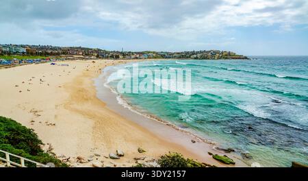 Vue panoramique de Bondi Beach à Sydney, Australie, avec ses rives sablonneuses et ses vagues turquoises. Banque D'Images