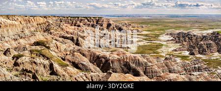 Vue panoramique ensoleillée et pittoresque sur les formations rocheuses érodées et colorées et la prairie lointaine depuis Homestead Overlook dans le parc national des Badlands, Dakota du Sud. Banque D'Images