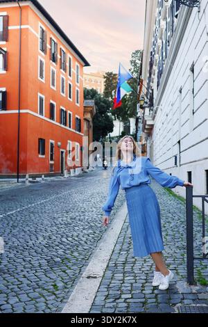Femme élégante profitant d'une promenade dans un quartier européen historique au coucher du soleil. Concept de voyage et de vie urbaine. Banque D'Images