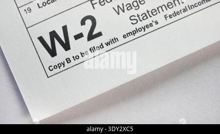 W-2 vue rapprochée de la déclaration des salaires et des impôts montrant le revenu fédéral et les détails de la paie pour la déclaration et la déclaration d'impôts annuels Banque D'Images