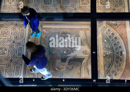 Visiteurs marchant sur le sol en verre avec le pavé en mosaïque représentant le concours de boisson entre Herakles et Dionysos fait au début du IIIe siècle Banque D'Images