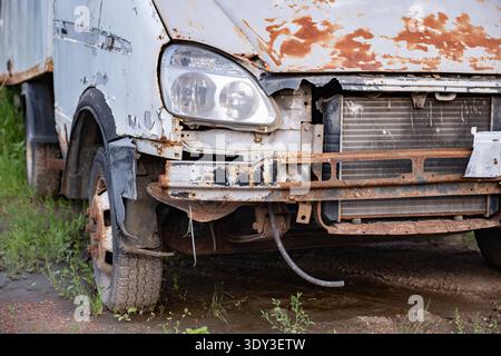 Camion commercial abandonné présentant de la rouille abondante, de la peinture écaillée et un pare-chocs manquant Banque D'Images