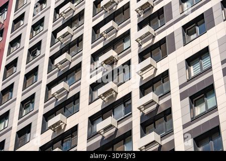 Façade de bâtiment résidentiel montrant l'architecture moderne et de nombreuses fenêtres avec climatiseurs Banque D'Images