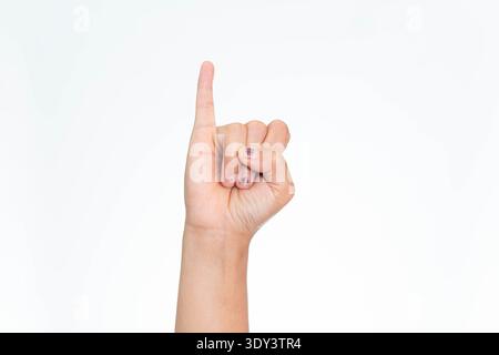 Gros plan de la main d'une femme indonésienne levant le doigt rose, symbolisant un serment ou une promesse rose, sur fond blanc. Banque D'Images