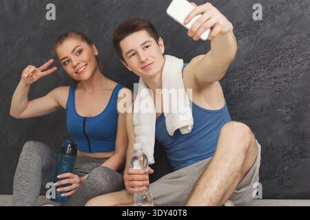 Jeune couple faisant selfie au gymnase Banque D'Images