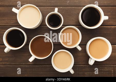 Différents types de café dans des tasses sur une table en bois, vue de dessus Banque D'Images