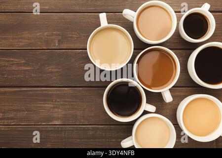 Différents types de café dans des tasses sur une table en bois, vue de dessus Banque D'Images