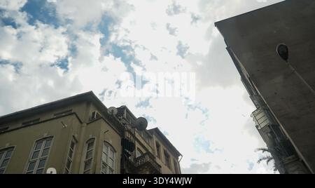 Vue architecturale à faible angle de bâtiments résidentiels anciens avec des évasions de feu en métal, des antennes paraboliques et des façades complexes. Banque D'Images
