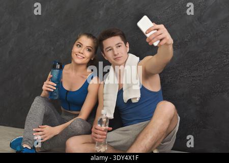Jeune couple faisant selfie au gymnase Banque D'Images