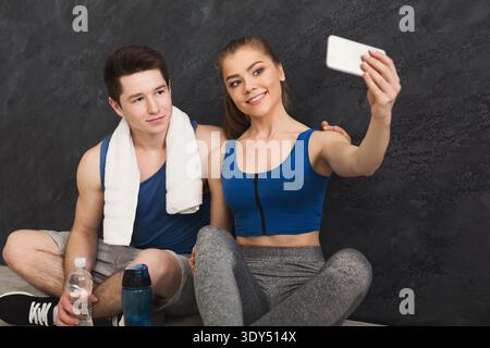 Jeune couple faisant selfie au gymnase Banque D'Images
