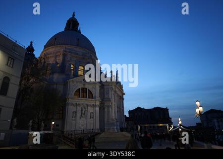 Vue nocturne de Santa Maria della Salute avec des lumières intérieures chaudes et un ciel bleu spectaculaire à Venise Italie. Banque D'Images