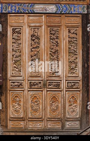 Portes en bois sculptées à la main exquises avec des motifs floraux et d'oiseaux complexes, artisanat chinois traditionnel et architecture. Banque D'Images