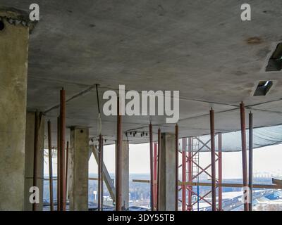 Une vue du chantier, montrant un plafond en béton soutenu par des poutres métalliques et des charpentes en bois, prêt pour la phase suivante. Banque D'Images