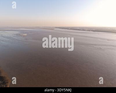 Vue aérienne montrant l'eau de marée à travers la rivière Mersey avec l'horizon de Liverpool au loin. Banque D'Images
