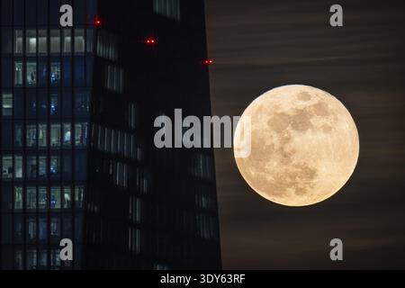 La lune passe derrière la Banque centrale européenne (BCE) à Francfort-sur-le-main. La pleine lune en mars est également connue sous le nom de lune de ver parce qu'elle le rappelle Banque D'Images