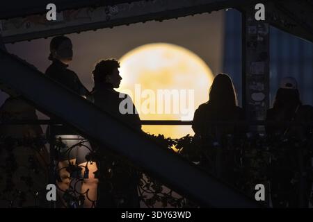 Les gens regardent la pleine lune levante depuis le pont de fer à Francfort-sur-le-main. La pleine lune en mars est aussi appelée lune vers parce qu'elle nous rappelle tha Banque D'Images