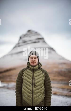 Portrait d'un homme portant un chapeau d'hiver devant Kirkjufell, Islande Banque D'Images