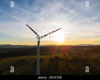 Les éoliennes se dressent sur une colline au coucher du soleil, représentant l’énergie renouvelable et le passage à la production d’énergie durable. Banque D'Images