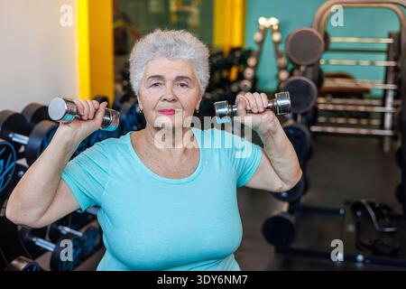 Femme âgée confiante faisant la formation de poids - Body positive Senior Fitness et Empowerment. femme construisant la force du haut du corps, les muscles des épaules et Banque D'Images