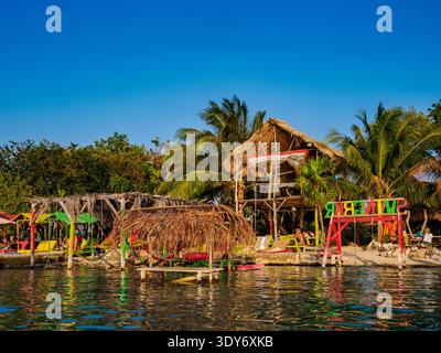 Les visiteurs apprécient les boissons et la détente au bord de l'eau au Swing Bar près de secret Beach à Ambergris Caye au Belize pendant une journée ensoleillée Banque D'Images