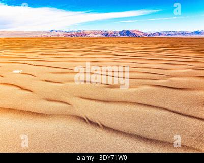 Les dunes de sable doré s'étendent à travers le paysage avec des volcans s'élevant en arrière-plan à Catamarca, en Argentine Banque D'Images