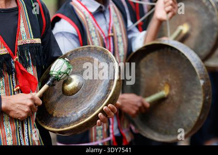 Les jeunes jouent des instruments de percussion lors d'une cérémonie traditionnelle dans un village ethnique Bahnar dans la région vietnamienne de Kontum Banque D'Images
