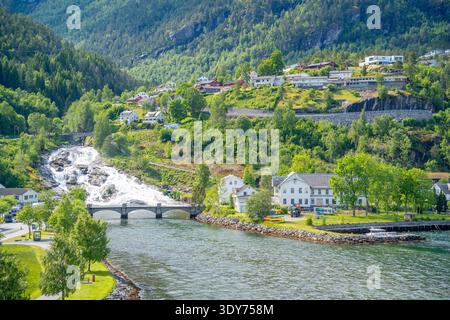 Vue ensoleillée de Hellesylt avec maisons, voie navigable et cascade dans la municipalité de Stranda, Norvège Banque D'Images