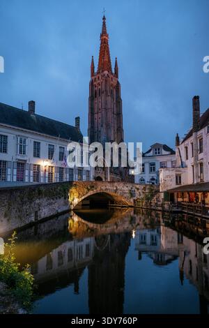 Vue sur le canal de Dijver et la tour à Bruges la nuit avec des reflets sur l'eau Banque D'Images