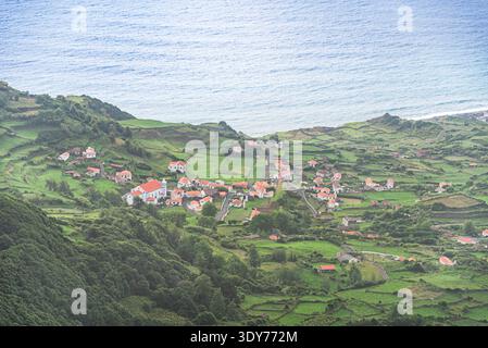 Vue panoramique sur la côte du village de Fajzinha avec des collines verdoyantes et l'océan Atlantique en arrière-plan sur l'île de Flores aux Açores Banque D'Images