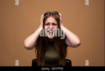 Jeune femme stressée criant, arrachant les cheveux, se sentant frustrée et dépassée, souffrant de problèmes de santé mentale Banque D'Images
