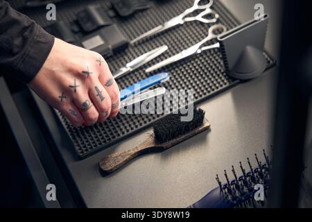 Barbier prenant rasoir droit de la table dans le salon de coiffure Banque D'Images