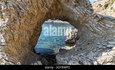 Arc de roche naturel encadrant la crique méditerranéenne sur l'île de Rhodes Grèce Banque D'Images