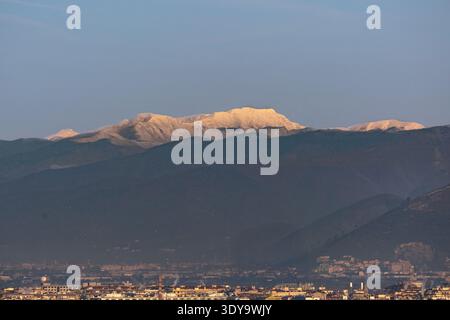 Toits de ville avec montagnes enneigées des Appennins en arrière-plan tous éclairés par les couleurs du lever du soleil, Florence Italie Banque D'Images