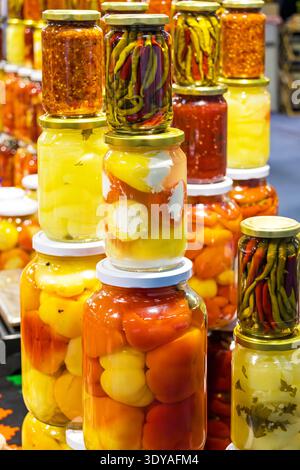 Grande pile de légumes fermentés dans des bocaux en verre vendus sur la place du marché Banque D'Images