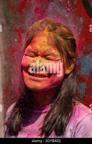 Joyeuse jeune femme couverte de poudre colorée pendant Holi Festival. Holi au Bangladesh est un beau mélange de dévotion spirituelle et d'harmonie culturelle Banque D'Images