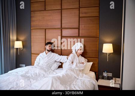 Tension entre couple dans la chambre d'hôtel portant des peignoirs Banque D'Images