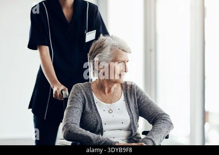 Fauteuil roulant, pensée et soignant avec une vieille femme à la maison pour le soutien, bénévole médical et aide parkinsons. Réadaptation, soins aux personnes âgées Banque D'Images