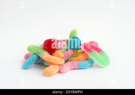 Assortiment de vers gommeux colorés et bonbons enrobés de sucre dispersés Banque D'Images